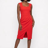 Red sleeveless square-neck sheath dress with high-waist band, faux-wrap pleating, and front slit, worn by a Black female