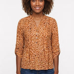 Woman wearing a brown leopard-print 3/4 roll-tab sleeve pullover top with Y-neck button detail, paired with dark jeans,