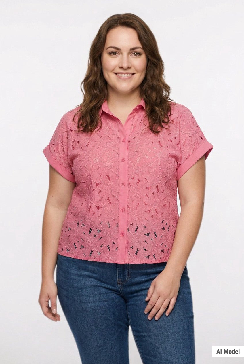 Plus-size model wears a coral pink short-sleeve eyelet button-front blouse with collar and cuffed sleeves; front view, waist