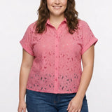 Plus-size model wears a coral pink short-sleeve eyelet button-front blouse with collar and cuffed sleeves; front view, waist